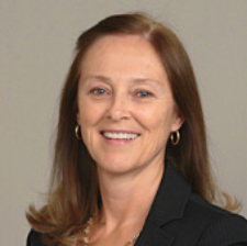 Photograph of Maureen Bellamy, presenting as a white female with long, medium brown hair. She is smiling.